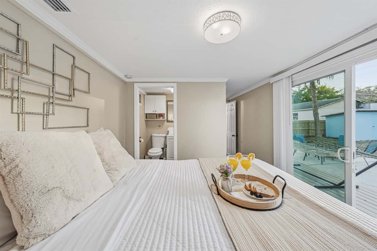 Master bedroom with plush bedding and direct access to the backyard.