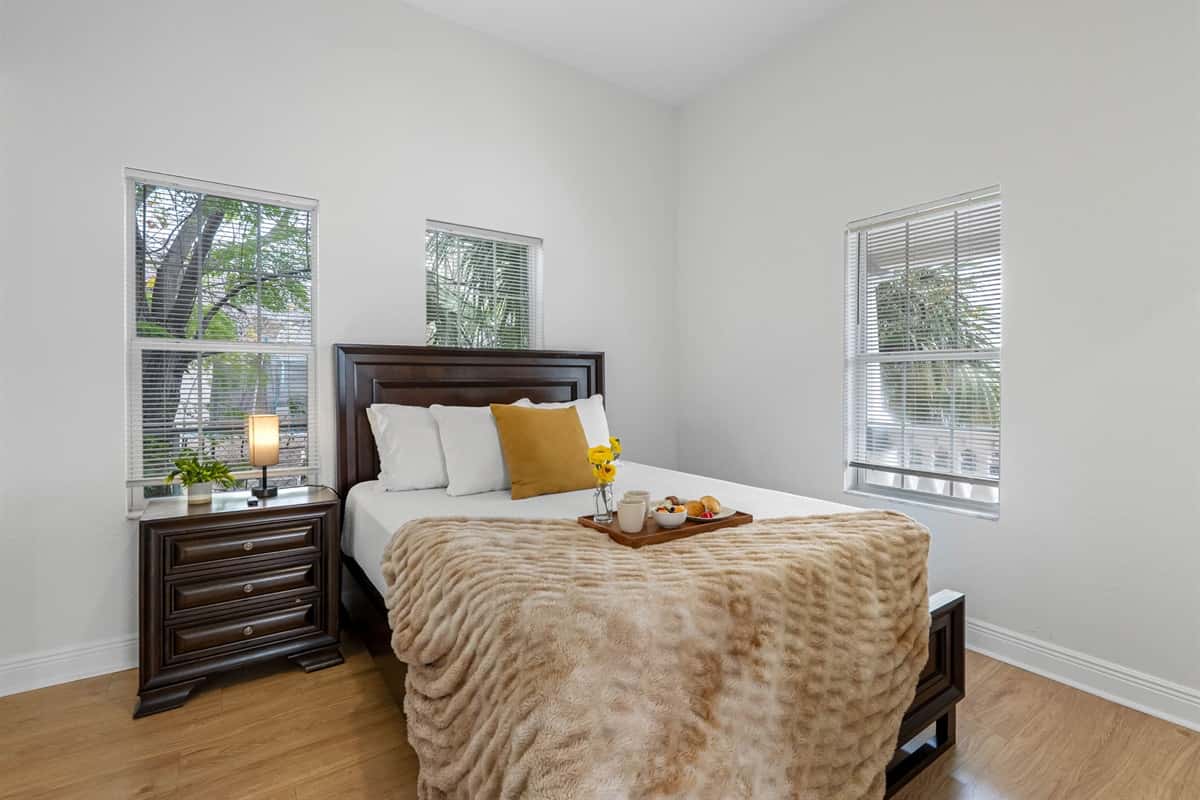 This serene bedroom features a comfortable bed, soft neutral décor, and natural light, creating a calm and inviting retreat.