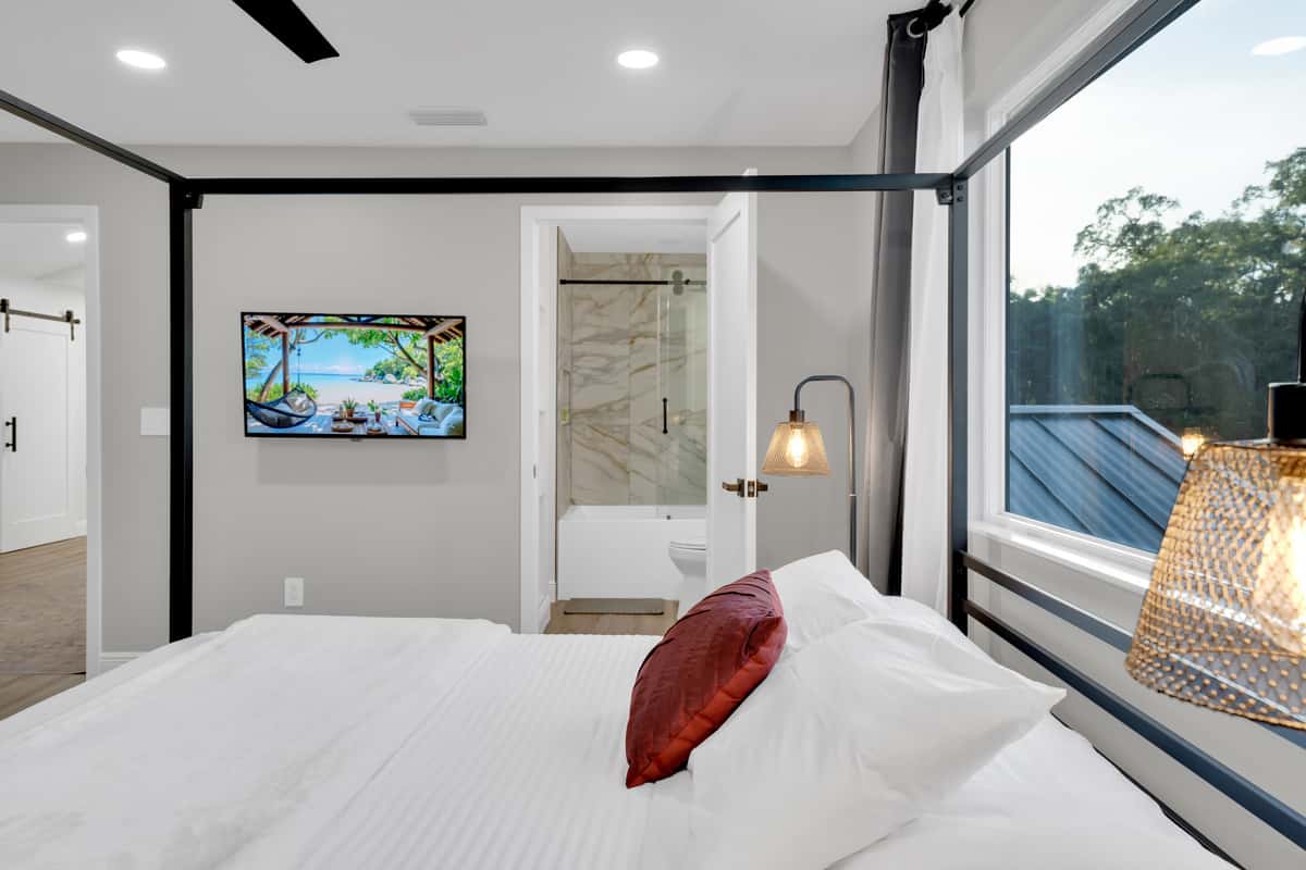 Bed, screen and your own bathroom door. Bright, high-ceilinged and quiet, with green outside the window and warm light for reading. The suite you settle into and never quite leave.