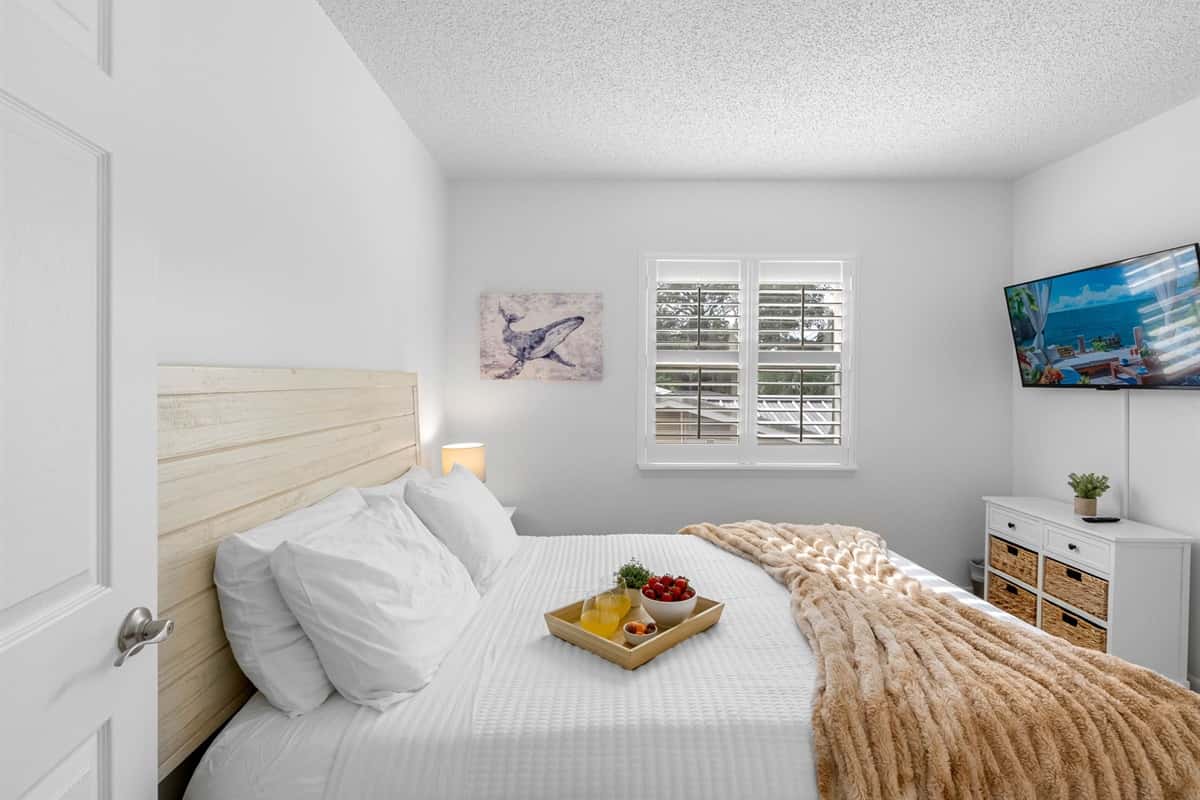 A cozy queen bedroom with a classic, clean design and plenty of natural light.