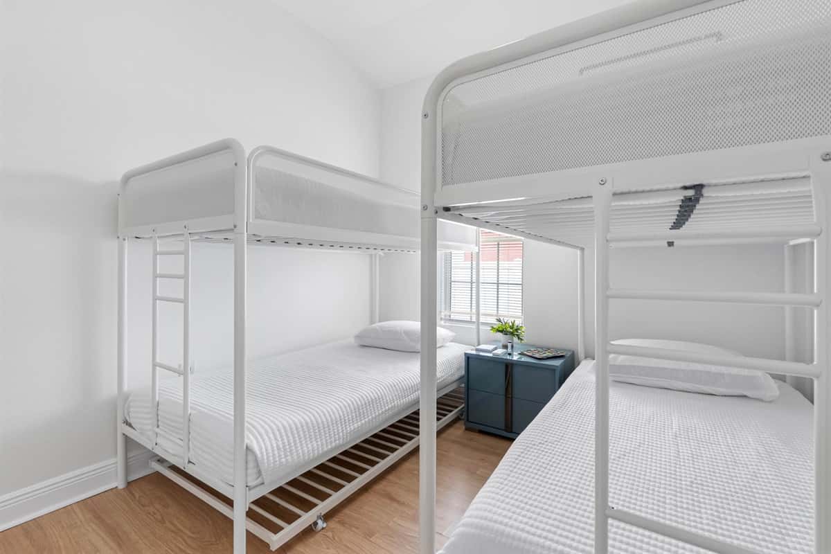 Bright and thoughtfully designed, this bunk bedroom features two modern twin-over-twin bunk beds, making it ideal for kids or groups. Clean lines, soft bedding, and natural light create a comfortable and welcoming space.