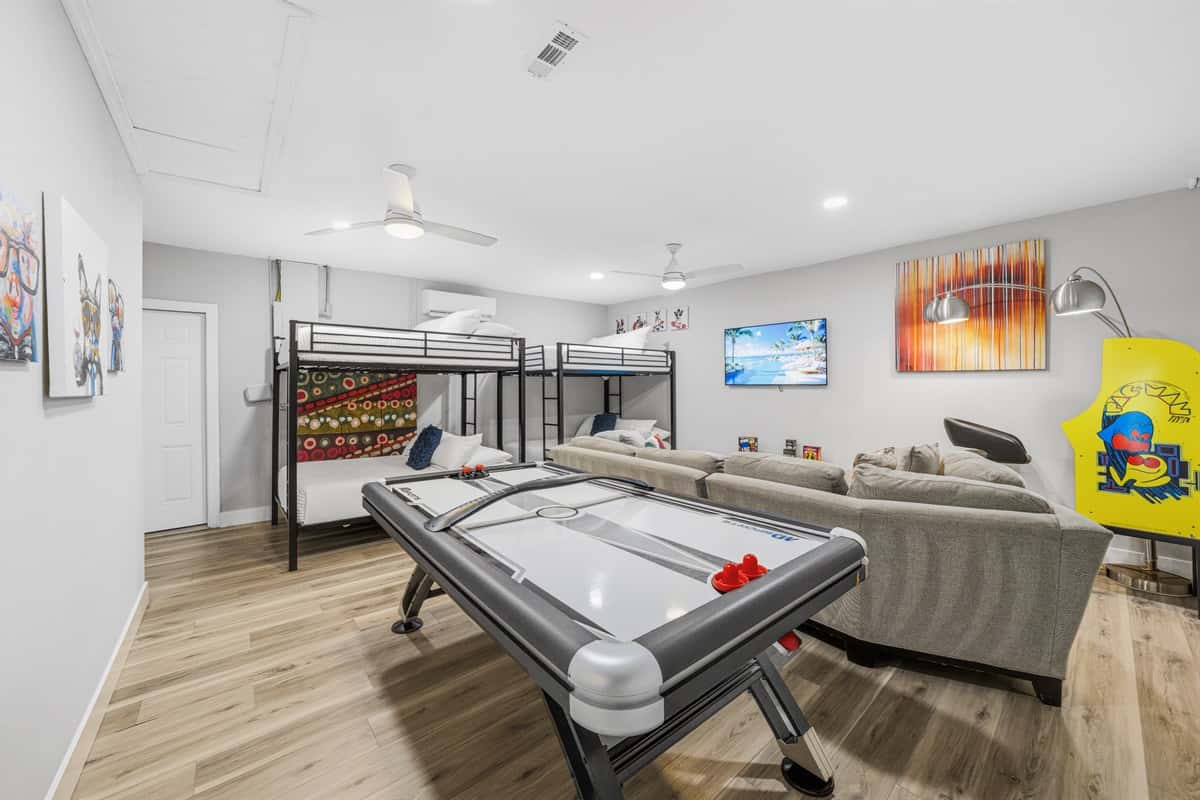 Ultimate game room with air hockey, arcade games, lounge seating, and bunk beds.