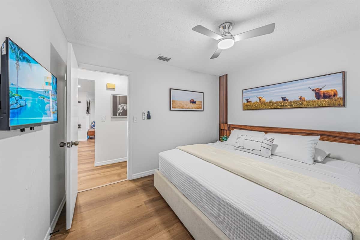 Large king bedroom featuring wall-mounted TV, modern décor, and plenty of open space to relax 