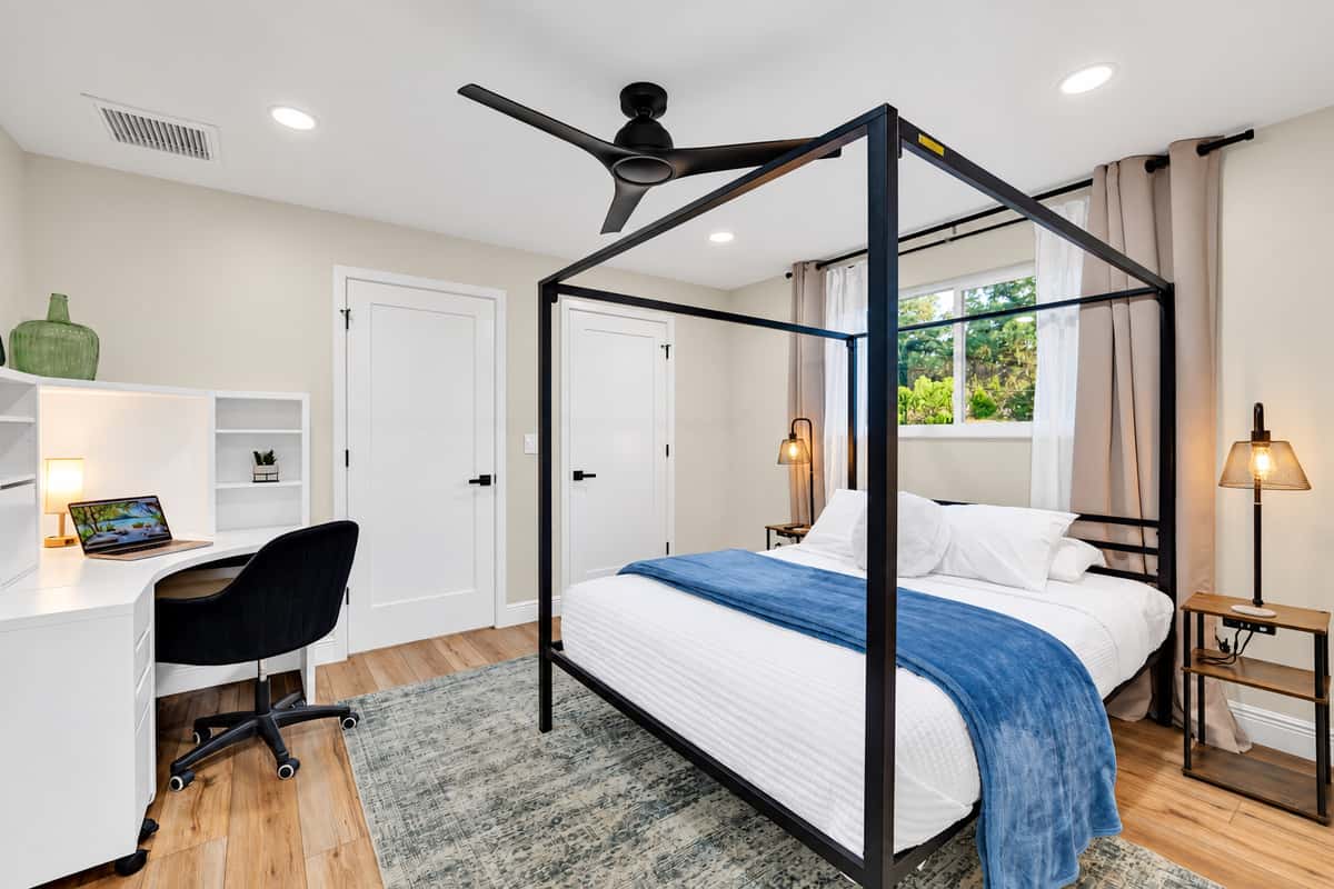 The suite you'll try to claim again next year. King canopy bed, warm bedside lamps and a workspace with a view of the trees — comfortable enough that leaving the room feels optional.