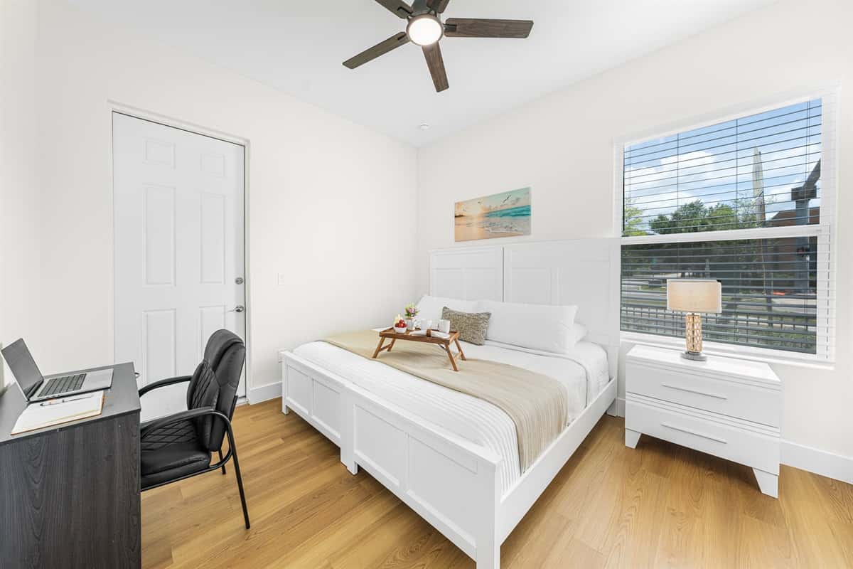 Cozy bedroom with comfortable bed, workspace, and plenty of natural light.