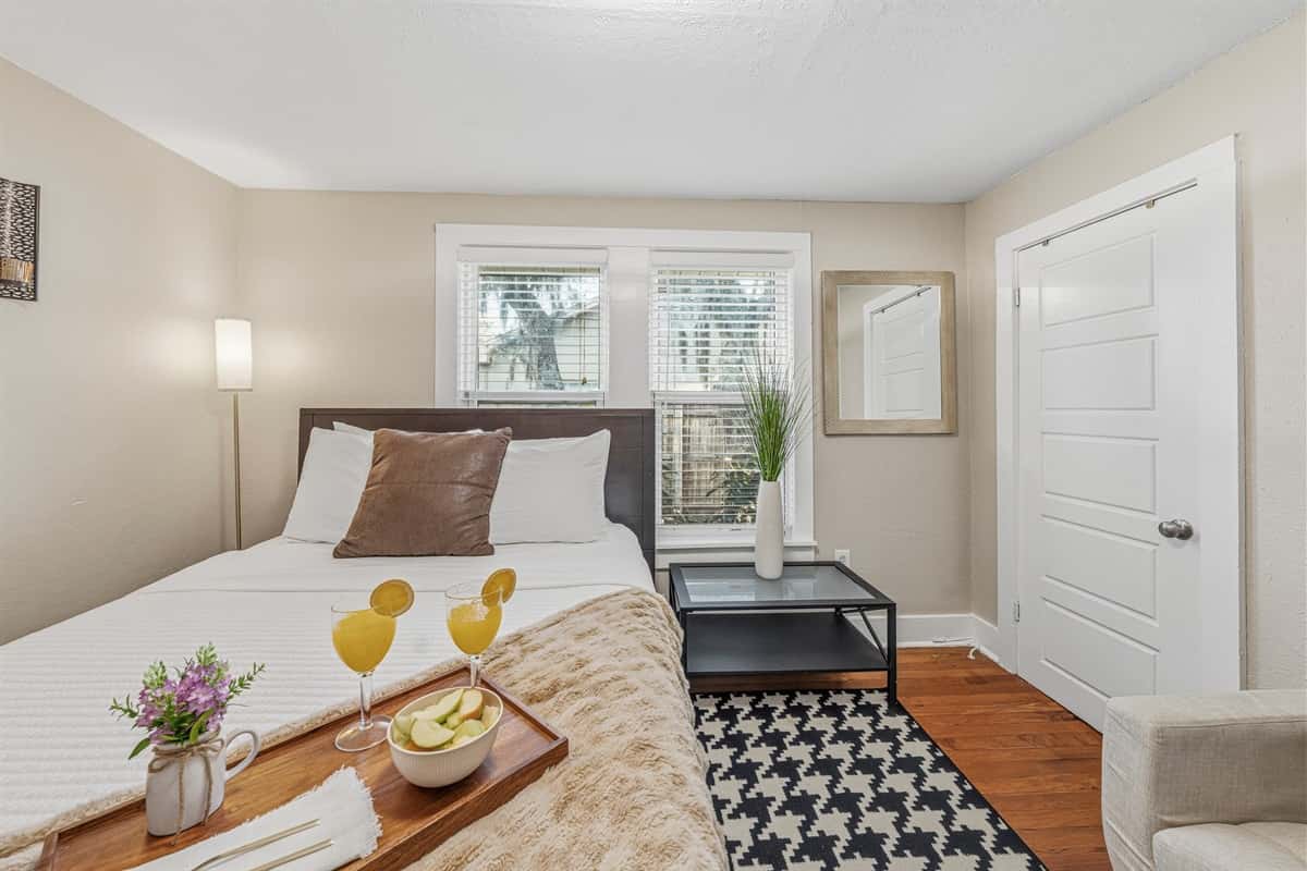 Cozy second bedroom with seating nook and warm, inviting touches.