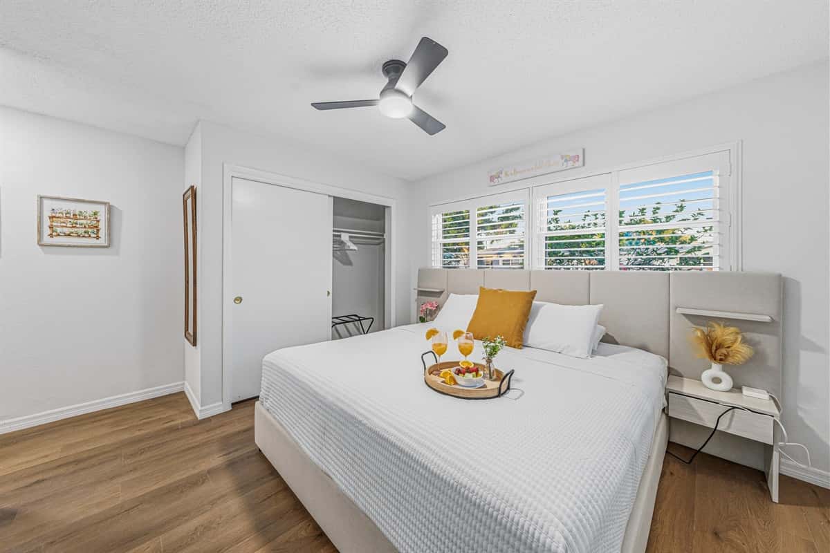 Bright and inviting king bedroom with clean design, natural light, and a relaxing atmosphere 
Tray and food setup shown are for staging purposes only and are not included.