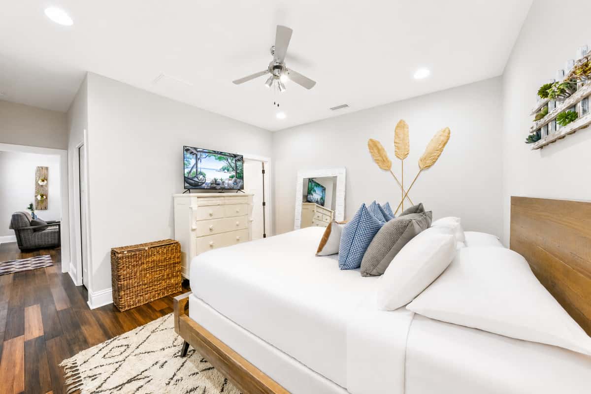 Unwind in the spacious primary bedroom featuring a king-size bed, Smart TV, and a peaceful atmosphere for a restful night's sleep.