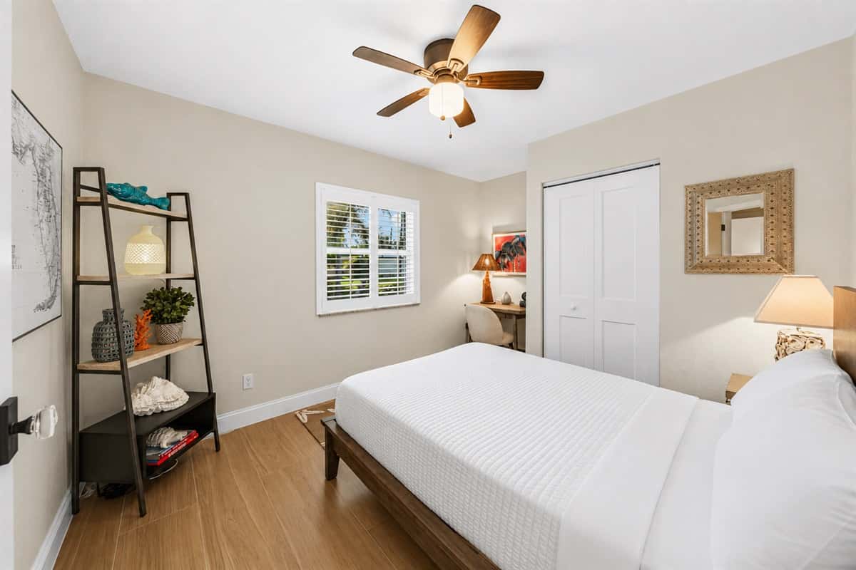 Bright and cozy bedroom featuring a comfortable bed, modern décor, and open shelving for added convenience.