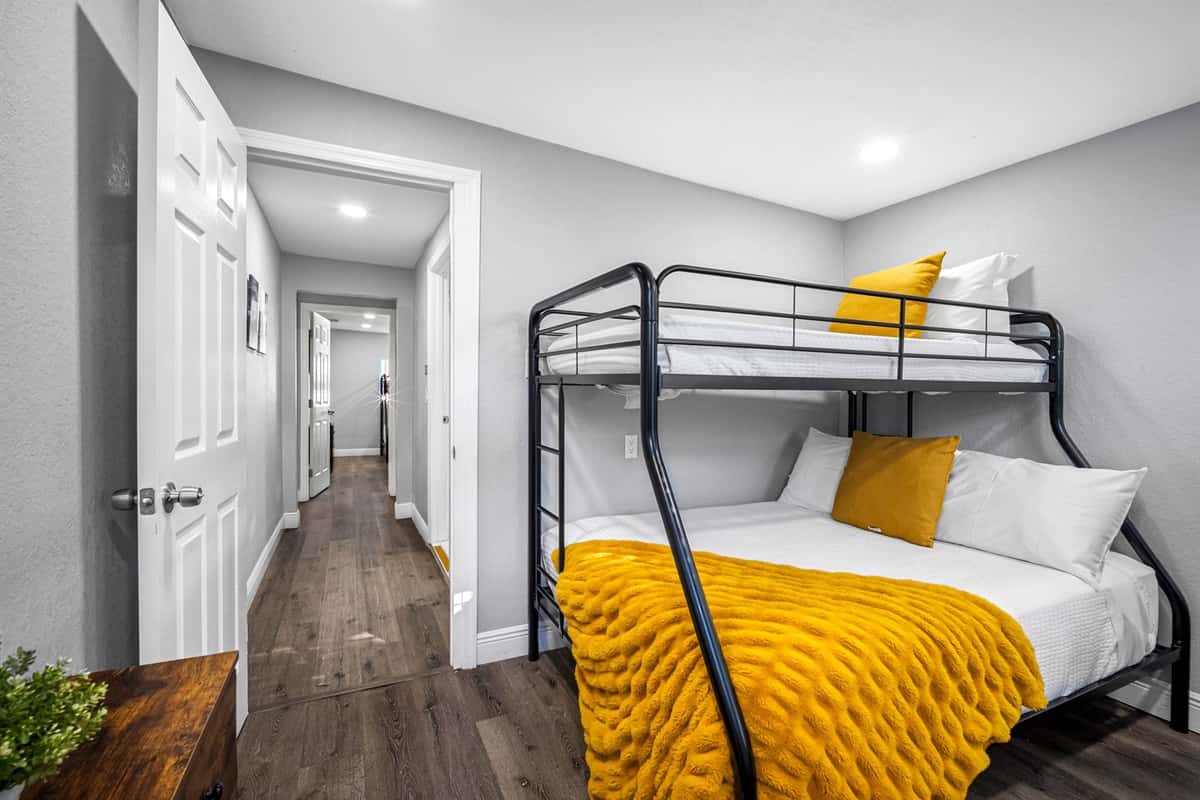 A cozy bunk room with soft lighting, modern décor, and vibrant yellow accents to create a welcoming vibe.