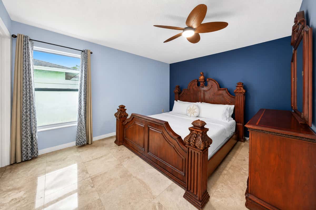 Comfortable king bedroom with natural light, ample space, and elegant décor for restful nights.