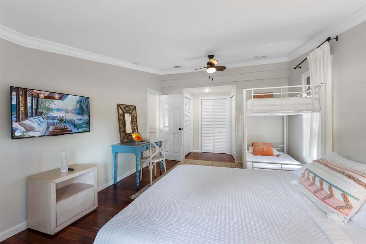 A versatile guest bedroom featuring a queen bed and a bunk bed, ideal for families or group stays.