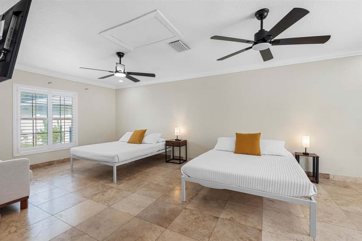 This inviting space features two plush queen-sized beds, each outfitted with soft, hotel-quality linens, cozy comforters, and an abundance of pillows to ensure a restful night’s sleep for every guest.