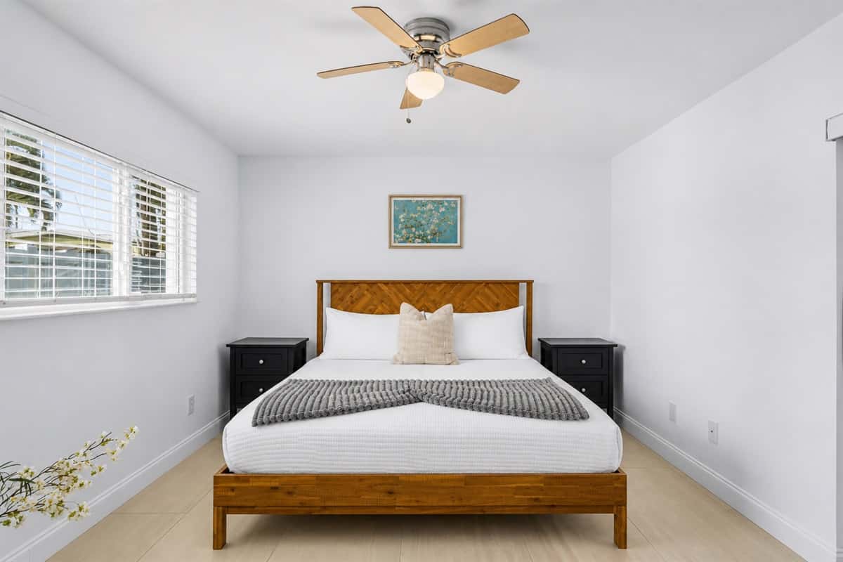 Bright and airy bedroom featuring a cozy wooden bed frame, modern décor, and natural lighting.
