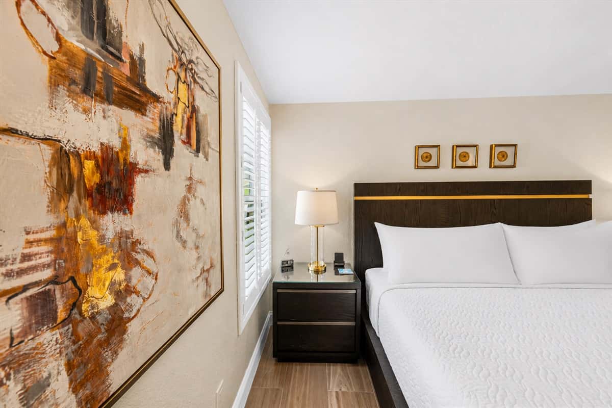 Comfortable king bedroom with stylish artwork, cozy lighting, and relaxing neutral tones.