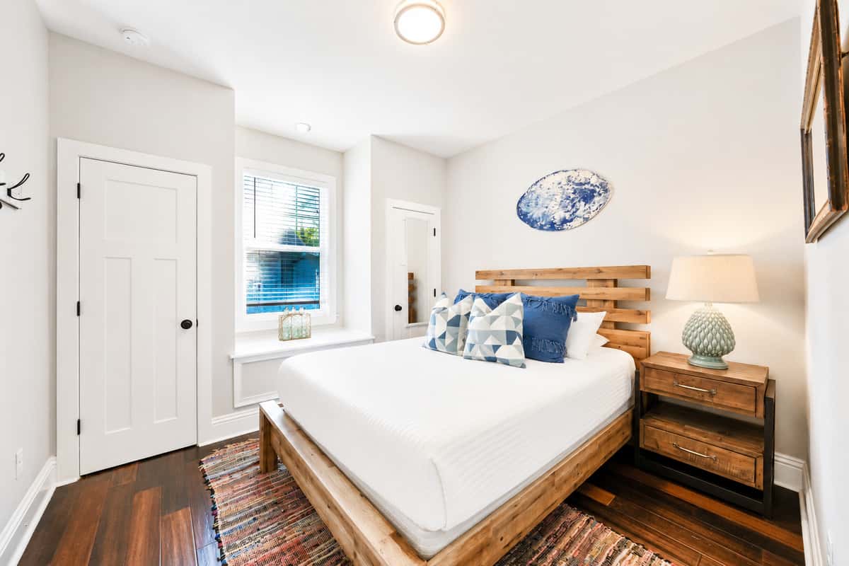 A welcoming guest bedroom with a comfortable queen-size bed, warm décor, and plenty of storage.