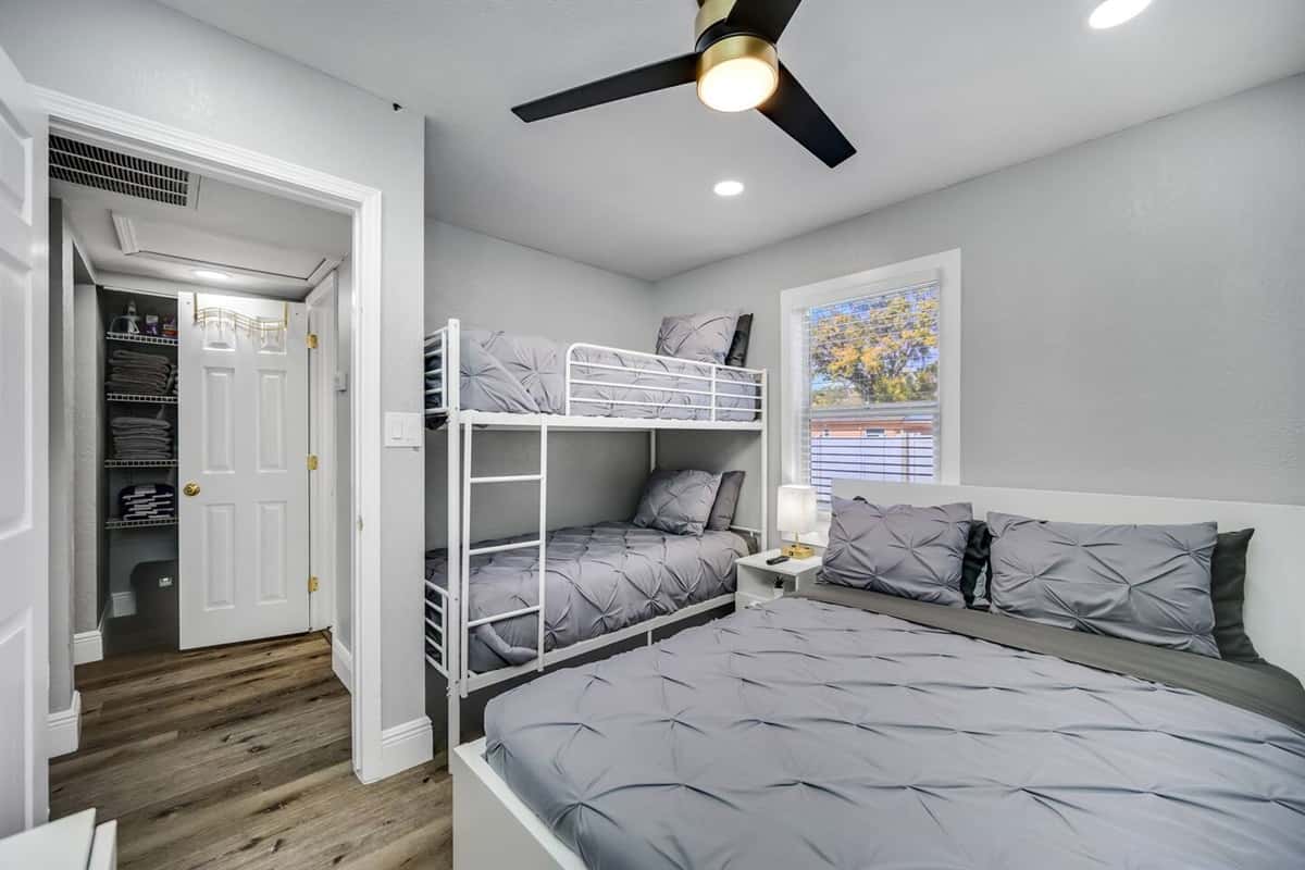 Immaculate bedroom with single bunkbed, queen sized bed, closet and smart TV.