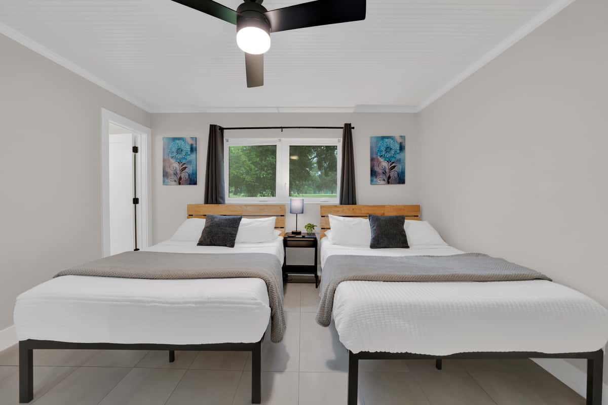 Wood headboards, gray throws, art that matches on both sides, simple, balanced, and easy to book with confidence.