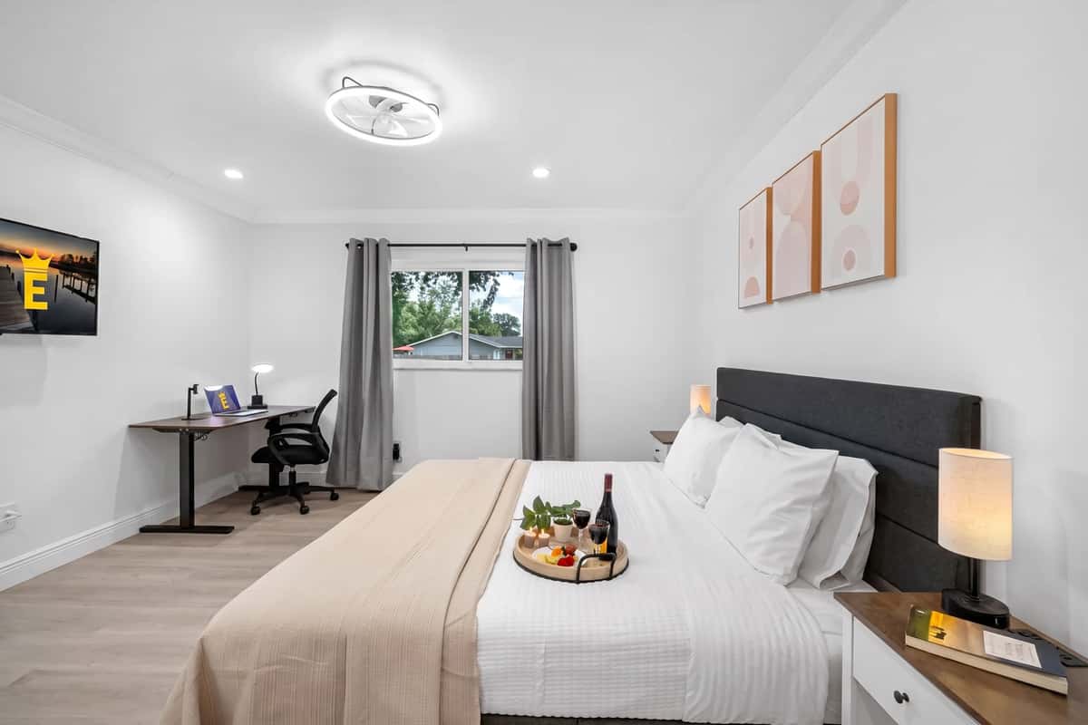 Stretch out on the plush king-size bed in this serene, hotel-inspired bedroom with fresh white linens and cozy lighting.