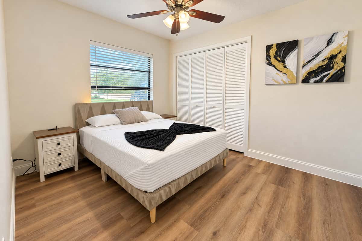 A calm, cozy queen bedroom. A queen bed with crisp white bedding, nightstand, ceiling fan and a large closet. Quiet, comfortable and perfect for a couple or solo traveler.