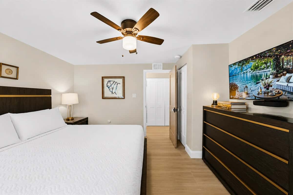 Bright and inviting king bedroom featuring a smart TV, dresser, and spacious layout for added comfort.