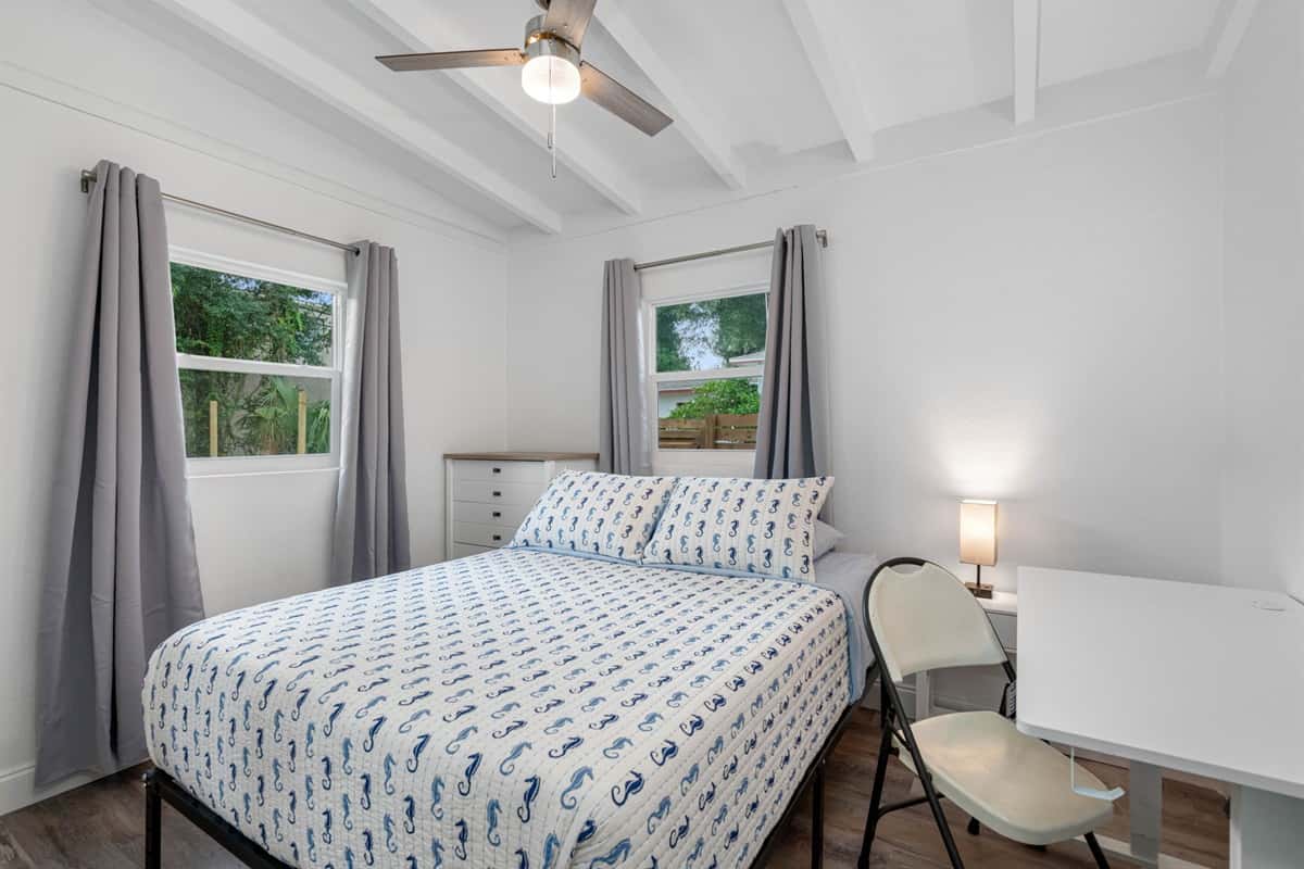 Sleep well, then get real work done. Bedroom 2 has a comfy queen bed, blackout-style curtains, a dresser, and its own work area. Business travelers and remote workers get rest and productivity in the same quiet room.