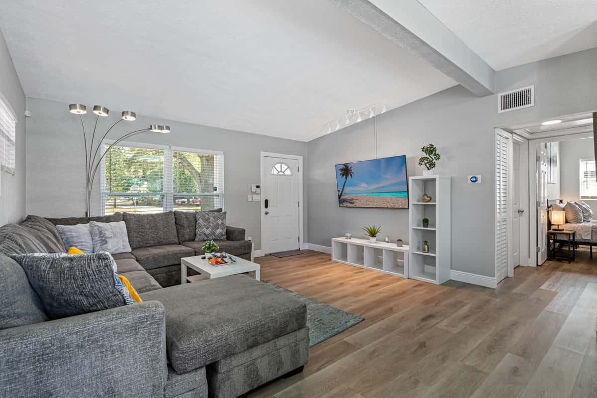 The living room is decorated with a plush grey carpet that adds texture and depth to the space while also providing a soft and cozy feel underfoot.