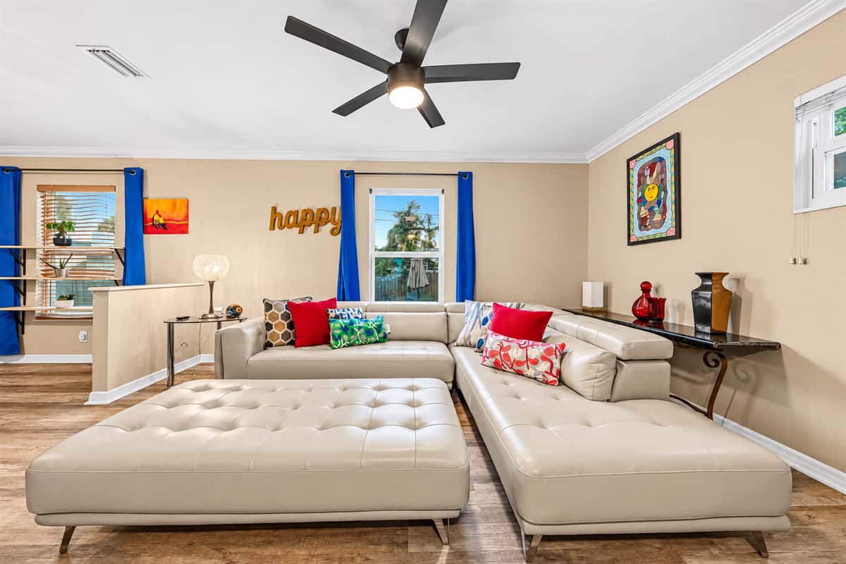 Comfortable living room with plush sectional, large TV, and vibrant accents for a cozy stay.