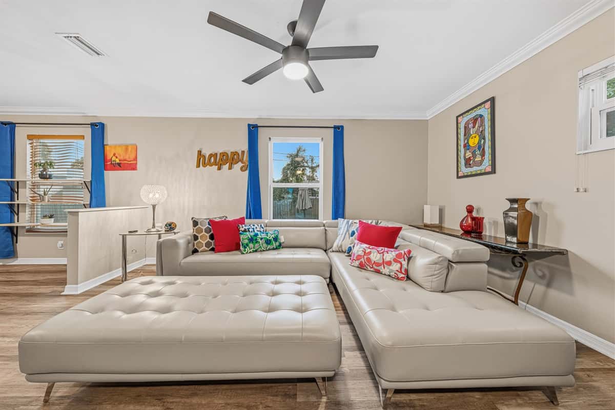 Comfortable living room with plush sectional, large TV, and vibrant accents for a cozy stay.