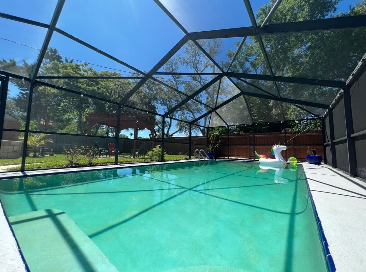 Spacious pool area enclosed by a screen for comfort, privacy, and bug-free relaxation.