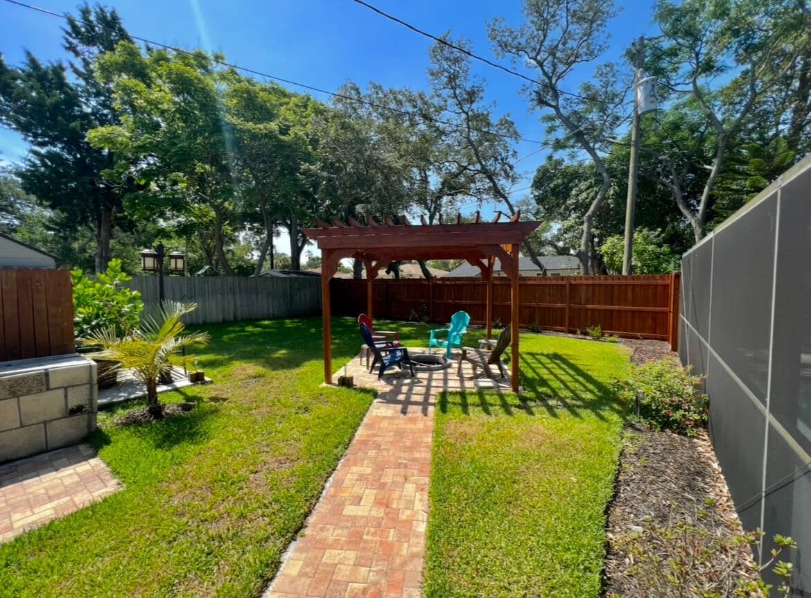A tranquil backyard spot with a stylish pergola and casual seating.