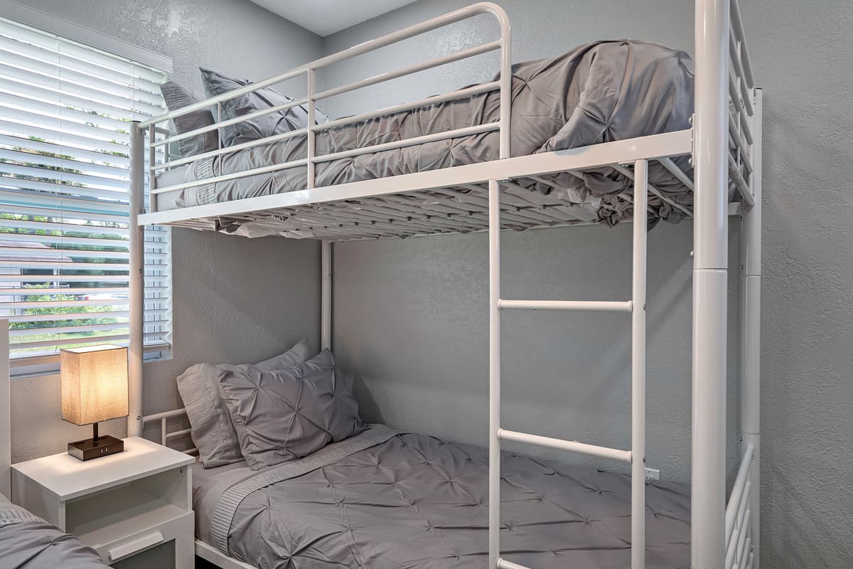 Cozy bedroom with single bunkbed, queen sized bed, drawers for storage and smart TV. Ideal room for a family with kids or a group of friends. 