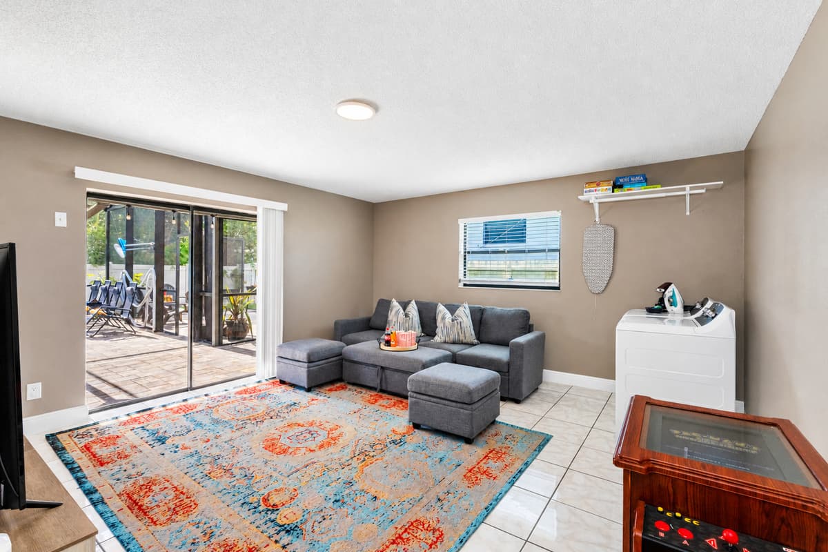 The room is bright and airy, thanks to a wide glass sliding door that leads directly to a screened patio—making indoor-outdoor living seamless.