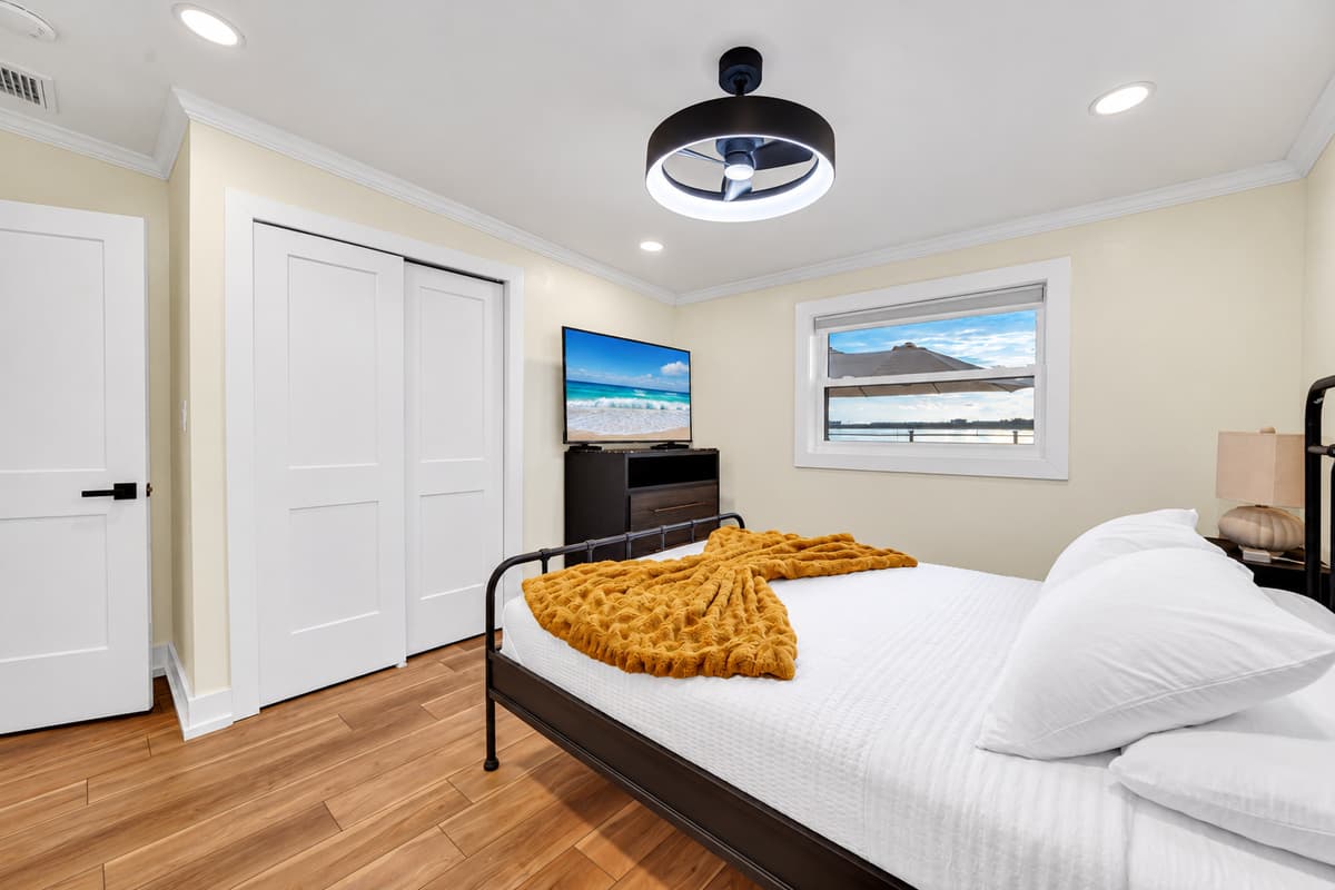 Queen bedroom with a TV and closet. A queen bed, wall TV, dresser and roomy closet. Unpack, settle in and feel at home for the week.
