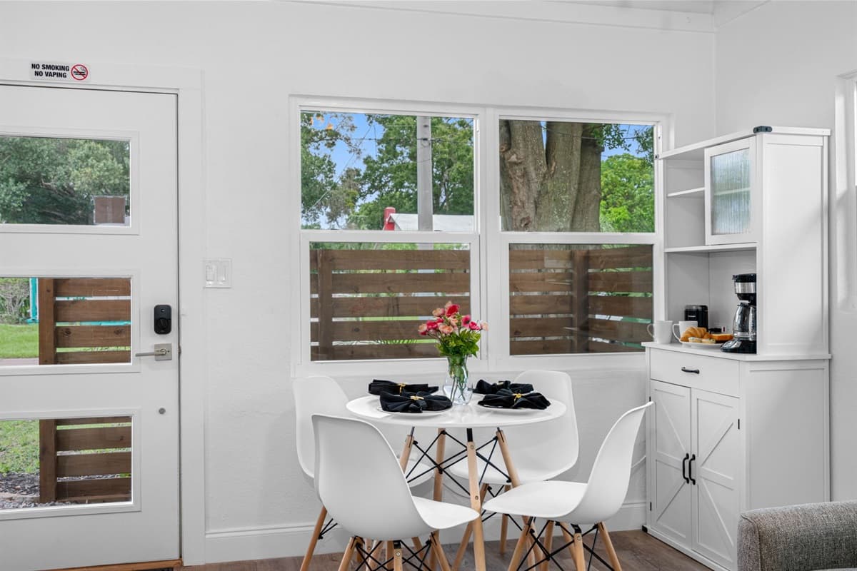 A stunning round dining table, featuring a sleek white finish that exudes elegance and simplicity.