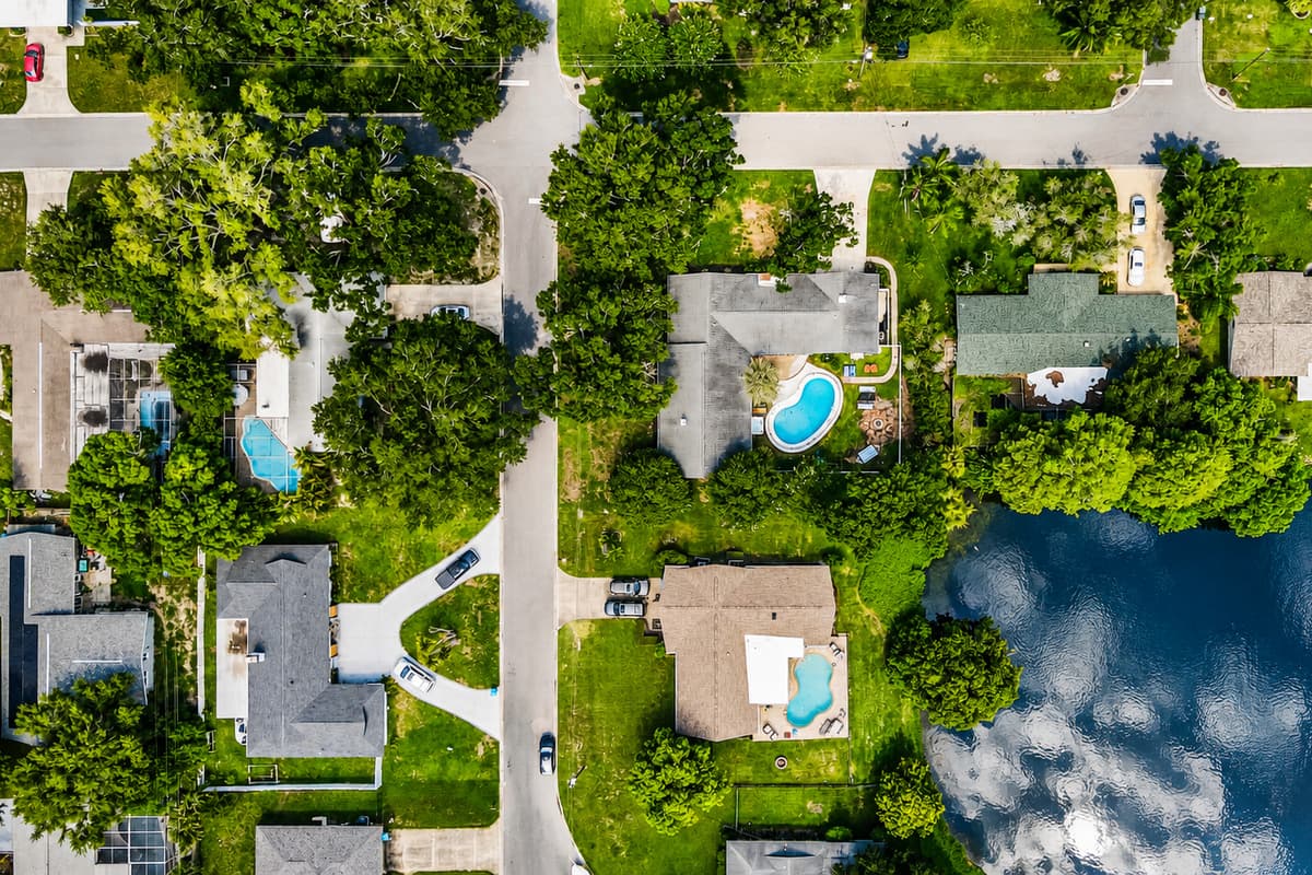 Pool below, lake behind, trees all around. The property lands right where the quiet is.