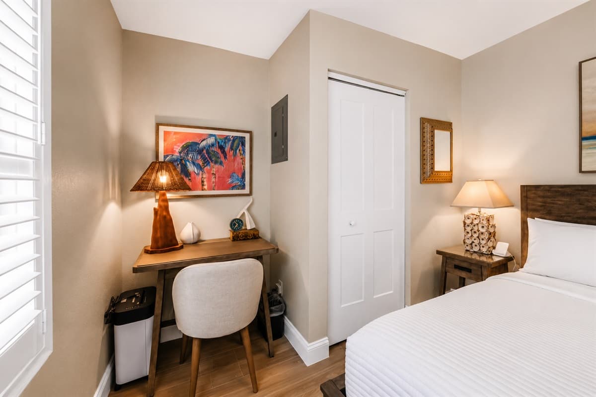 Comfortable bedroom with a dedicated workspace, stylish furnishings, and relaxing natural tones.