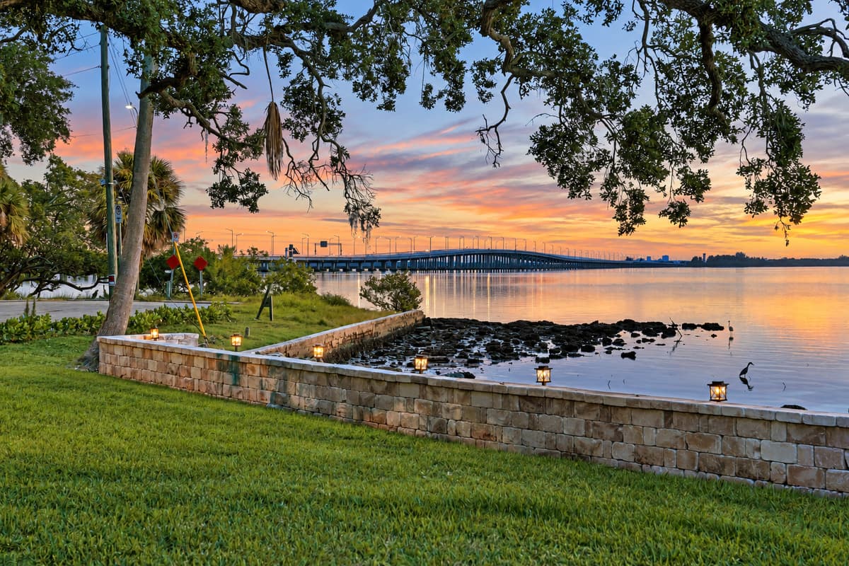 Golden hour under the oaks. The sun sets behind the bridge as the lights along the seawall start to glow. Quiet, beautiful and all yours.