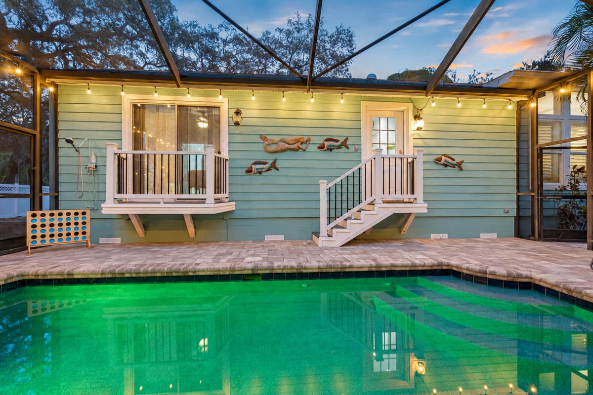 Swim or relax in this private pool oasis featuring soft lighting, tropical surroundings, and an easy transition to the outdoor entertainment area.