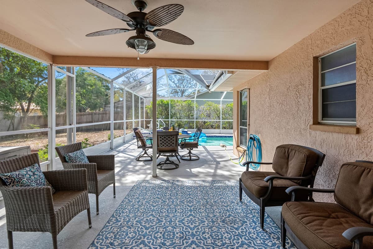 Adjacent to the pool, the covered patio features a dining table and seating, making it an ideal spot for casual family meals, and lively conversations.