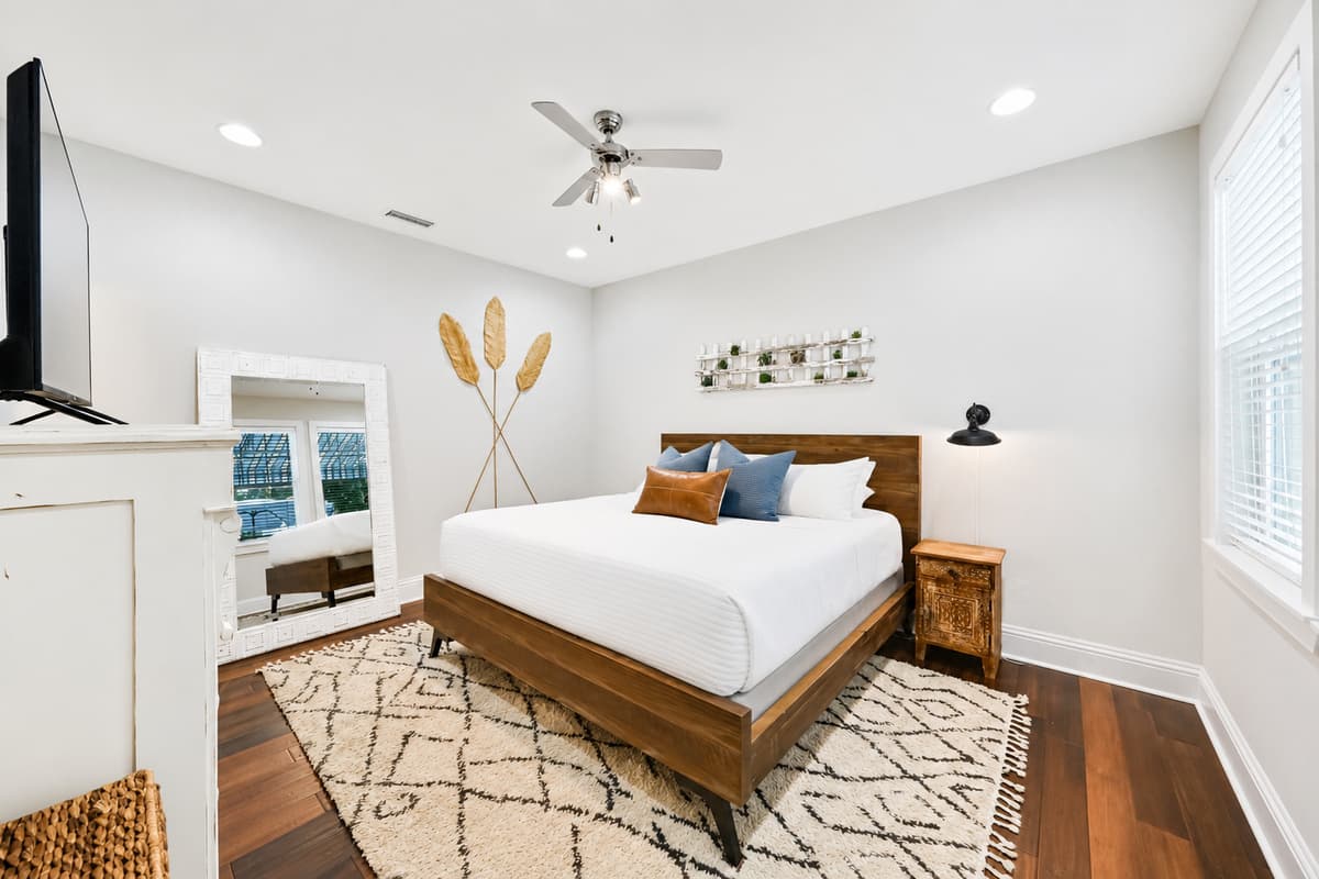 Relax in the spacious primary bedroom featuring a comfortable king-size bed, Smart TV, and elegant coastal décor.