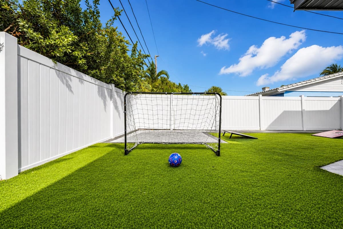 Private backyard soccer area with artificial turf and secure fencing.