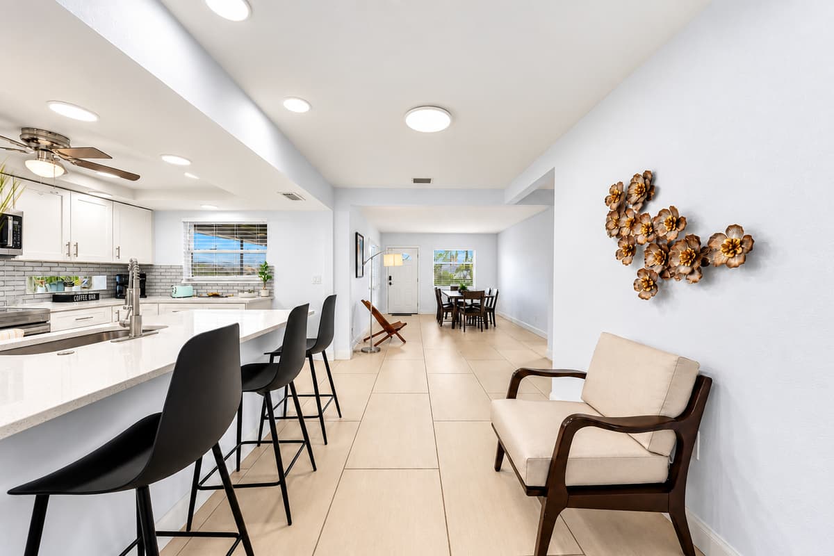 Wide-angle kitchen view showcasing the open-concept layout and comfortable breakfast bar seating.