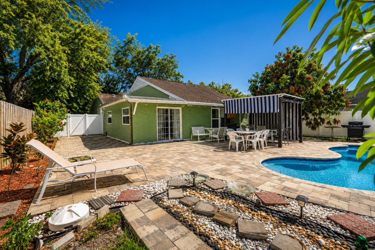Relax in a private tropical setting featuring a sparkling pool, lounge chairs, and plenty of outdoor space.