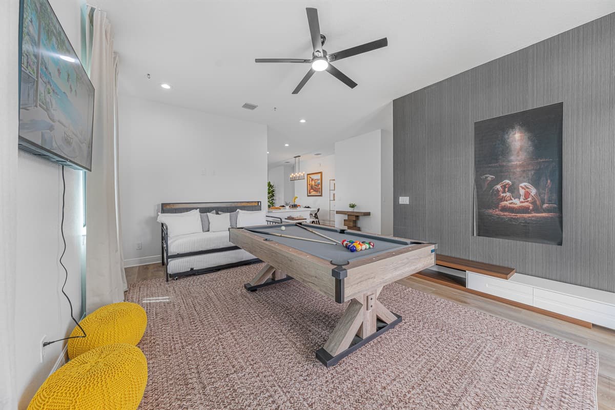 Modern game room with stylish design, pool table, and a comfortable lounge setup for guests.