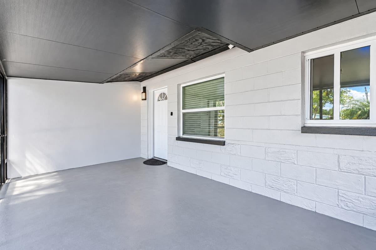 A covered entry, shaded and dry. The covered area by the side entrance keeps you shaded while unloading bags and beach gear. A smart detail on rainy Florida afternoons.