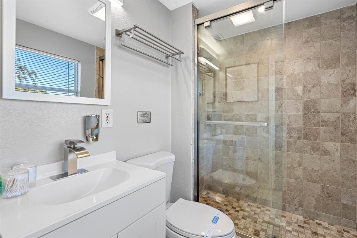 Well-appointed bathroom, complete with a bathtub, sink, toilet, and a convenient shower. Relax and unwind with a soothing bath after a long day of travel, making our place your home away from home.