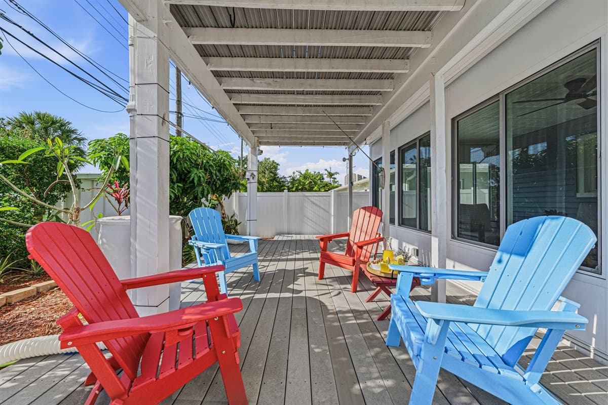 Covered patio with multiple seating areas overlooking the pool—great for relaxing in the shade 