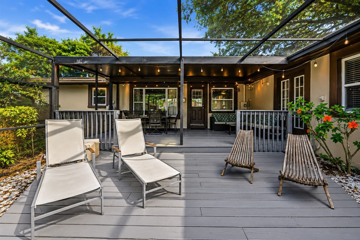 Expansive outdoor living area featuring lounge chairs, covered seating, and a resort-style atmosphere.