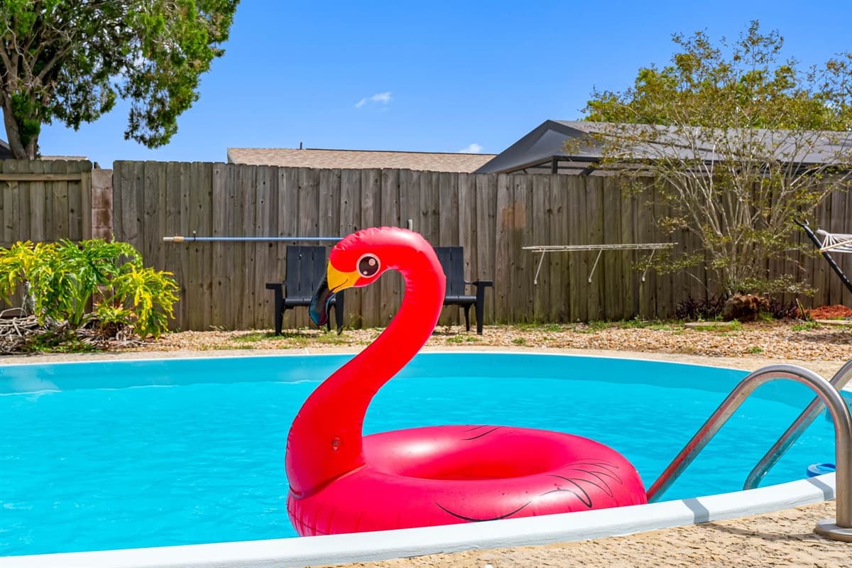 This fully fenced backyard is a tropical playground with a crystal-clear pool, vibrant landscaping, and ample space for lounging, games, or simply soaking in the Florida sunshine.